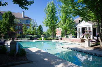 Outdoor pool with white columns and decorative urns